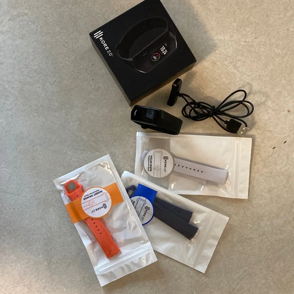 Kore Fitness Tracker. Tracker, charger, and three extra wrist bands.